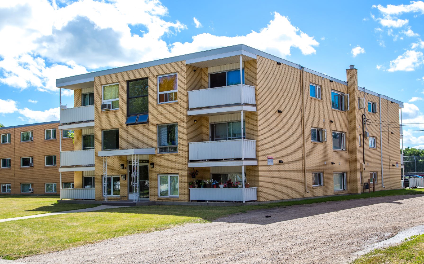 a view of a building with a dirt road in front of it